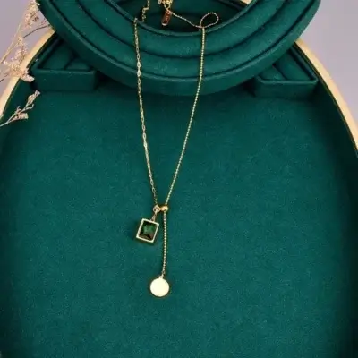 Collier Rectangle vert posé sur fond vert