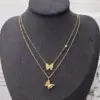 Collier papillon en acier posé sur un présentoir noir