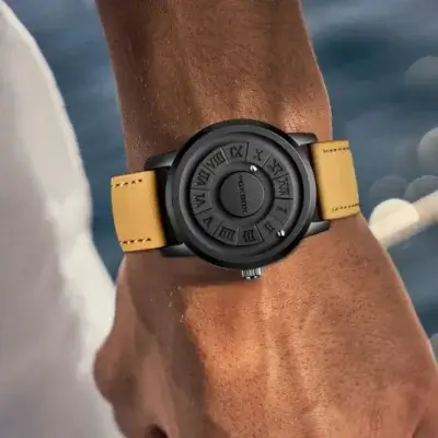 Accessoire homme au design innovant : montre DOM avec cadran noir texturé et bracelet en cuir jaune.