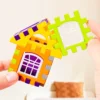 Main d’enfant manipulant des blocs de construction éducatifs, en train d’assembler un puzzle coloré aux formes simples et amusantes.