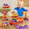 Petit garçon souriant en train de construire avec des blocs colorés — jeu éducatif qui développe motricité fine, concentration et créativité dès 3 ans.