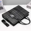 Sac business en cuir pour homme, avec motif carreaux gris, posé sur un bureau avec ordinateur portable — idéal pour les professionnels en déplacement ou au travail.