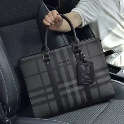 Homme tenant un sac business en cuir dans une voiture, soulignant sa praticité lors des déplacements professionnels ou des trajets quotidiens.