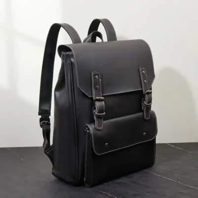 Sac à dos vintage en cuir synthétique noir, étanche et robuste, avec fermeture à rabat et surpiqûres blanches — parfait pour un look rétro tout en restant fonctionnel.