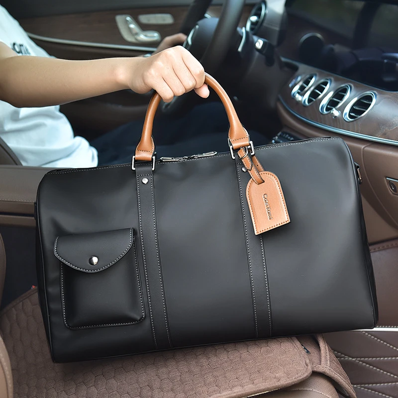 Sac de voyage en cuir noir posé sur le siège d’une voiture de luxe, soulignant son style raffiné et sa praticité pour les déplacements professionnels ou personnels.