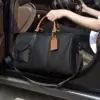 Sac de voyage en cuir noir glissé dans une voiture, prêt pour un départ — conçu pour s’adapter à tout véhicule grâce à sa forme compacte et ses poignées solides.