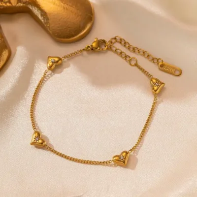 Bracelet en acier inoxydable avec cœurs scintillants posé sur un tissu soyeux — idéal comme cadeau romantique pour elle, à l’occasion d’un anniversaire, la Saint-Valentin ou la fête des mères.