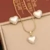 Ensemble bijoux d’amour en forme de cœur : collier et boucles d’oreilles avec perle nacrée entourée de strass — idéal pour une touche romantique et élégante.