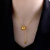 Collier en acier inoxydable doré avec pendentif boule ronde et barre verticale — design minimaliste et élégant, parfait pour un look moderne et sophistiqué.