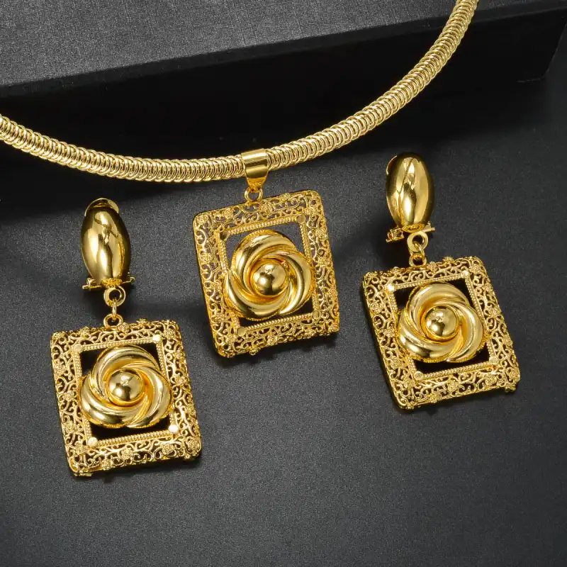 Ensemble collier et boucles d’oreilles doré avec fleurs sculptées, présenté sur fond noir — bijoux de mariage luxueux et élégant, parfaits pour briller lors d’un grand jour.