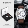 Coffret montre d’affaires pour homme TOMI, incluant une montre avec cadran « face gear » et deux bracelets interchangeables (cuir marron et noir) — design simple, créatif et professionnel.