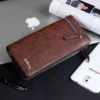 Portefeuille long Baellerry marron, finition vieillie élégante, posé à côté d’un MacBook et d’un smartphone Samsung — style urbain et fonctionnel pour les hommes modernes.