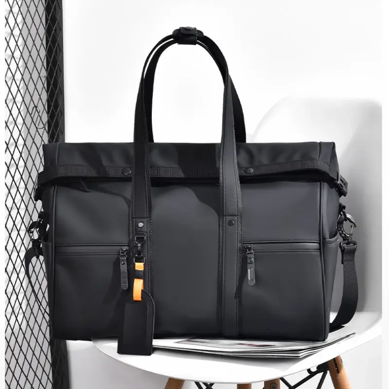 Sac de sport noir uni, finition mate et bandoulière ajustable, posé sur une chaise blanche — look urbain et minimaliste, parfait pour les déplacements professionnels ou loisirs actifs.