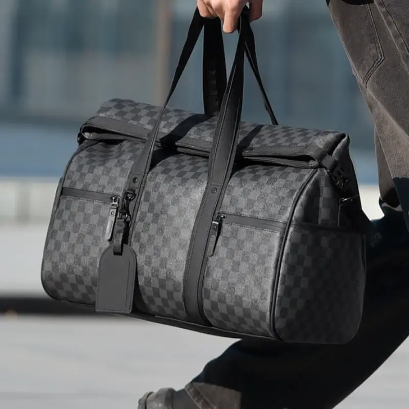 Homme transportant un sac de sport à motif damier lors d’un déplacement urbain — léger, ergonomique et spacieux, conçu pour la gym, le week-end ou les activités aquatiques.