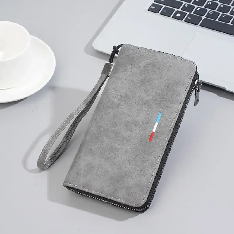 Portefeuille homme long zippé en simili-cuir gris, avec détail tricolore (bleu-blanc-rouge), bandoulière amovible et finition mate — design moderne et pratique pour le quotidien ou les déplacements.