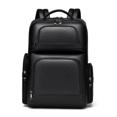 Sac à dos professionnel en simili-cuir noir texturé posé sur un tabouret en bois, mettant en valeur les multiples compartiments zippés et la poignée supérieure.