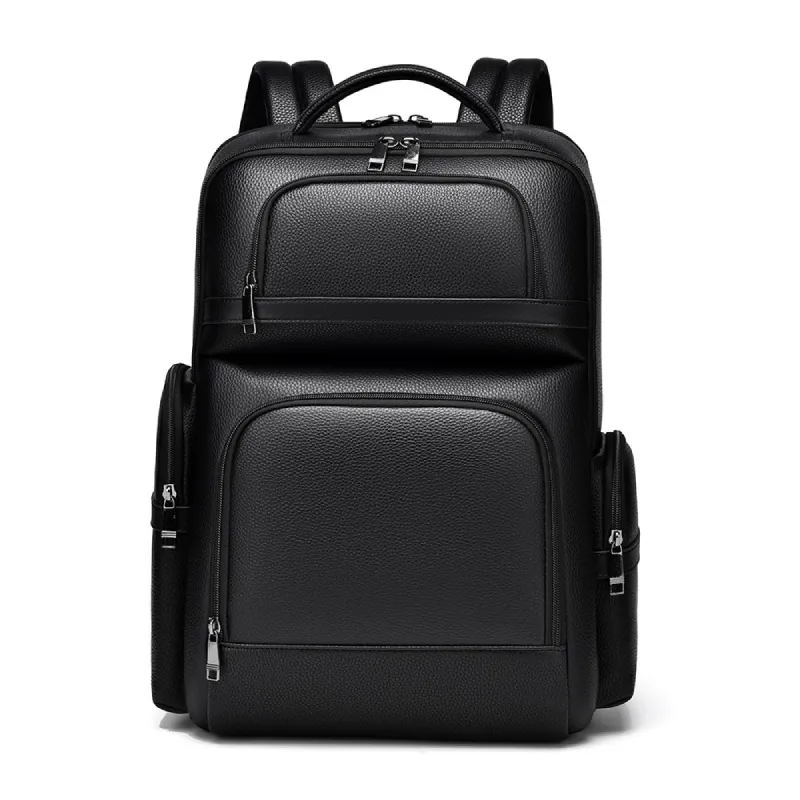 Sac à dos professionnel en simili-cuir noir texturé posé sur un tabouret en bois, mettant en valeur les multiples compartiments zippés et la poignée supérieure.