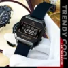 Montre digitale OLEVS 1103 style trendy cool tenue par une main gantée blanche, mettant en valeur son boîtier rectangulaire noir mat et son bracelet sport en silicone.