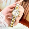 Montre OLEVS 3621 tenue à la main, détail du bracelet en acier poli bicolore et du cadran avec dateur, montrant la finition soignée et le style raffiné.