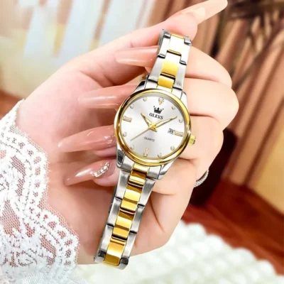 Montre OLEVS 3621 tenue à la main, détail du bracelet en acier poli bicolore et du cadran avec dateur, montrant la finition soignée et le style raffiné.