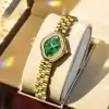 Montre OLEVS 5666 présentée dans un coffret cadeau sur coussin blanc, éclairage luxueux mettant en valeur le cadran vert et le bracelet doré, idéale comme idée cadeau.