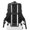 Dos du sac à dos business noir fixé sur la poignée télescopique d'une valise grâce à une sangle bagage intégrée — pratique pour les voyages d'affaires et le transport combiné.