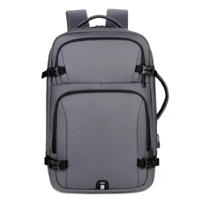Vue de face du sac à dos homme gris anthracite avec boucles de compression noires, bande réfléchissante inférieure et multiples compartiments zippés — style rétro moderne et fonctionnel.