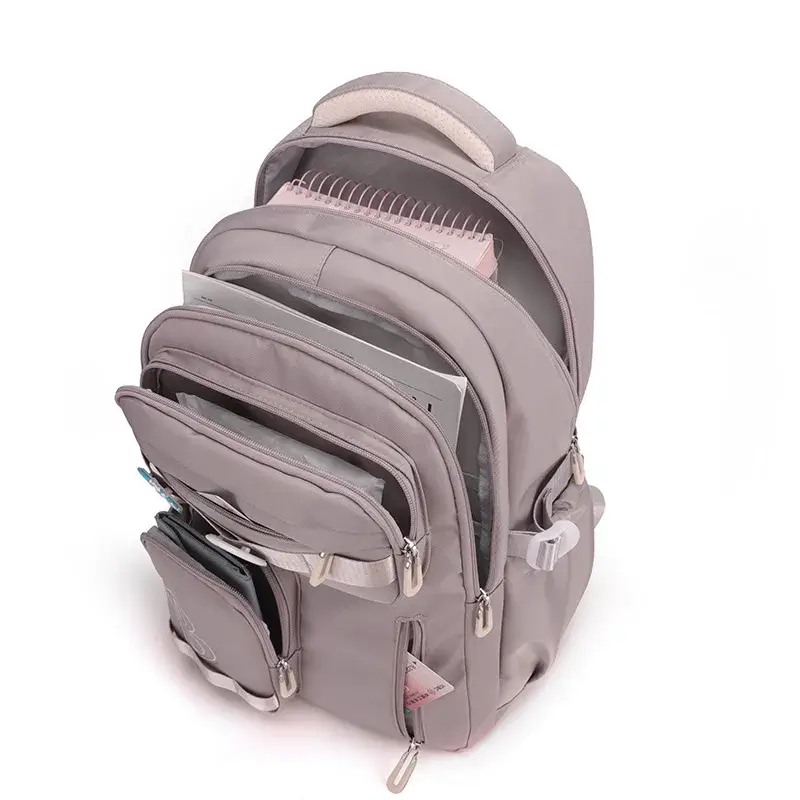 Intérieur organisé du sac à dos scolaire grande capacité montrant les multiples compartiments remplis de cahiers, livres et fournitures — design ergonomique et pratique pour l'école.