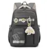 Sac à dos scolaire vert foncé unisexe avec porte-clés nuage et badges décoratifs, bretelles rembourrées et poches latérales, idéal pour le collège et les déplacements quotidiens.