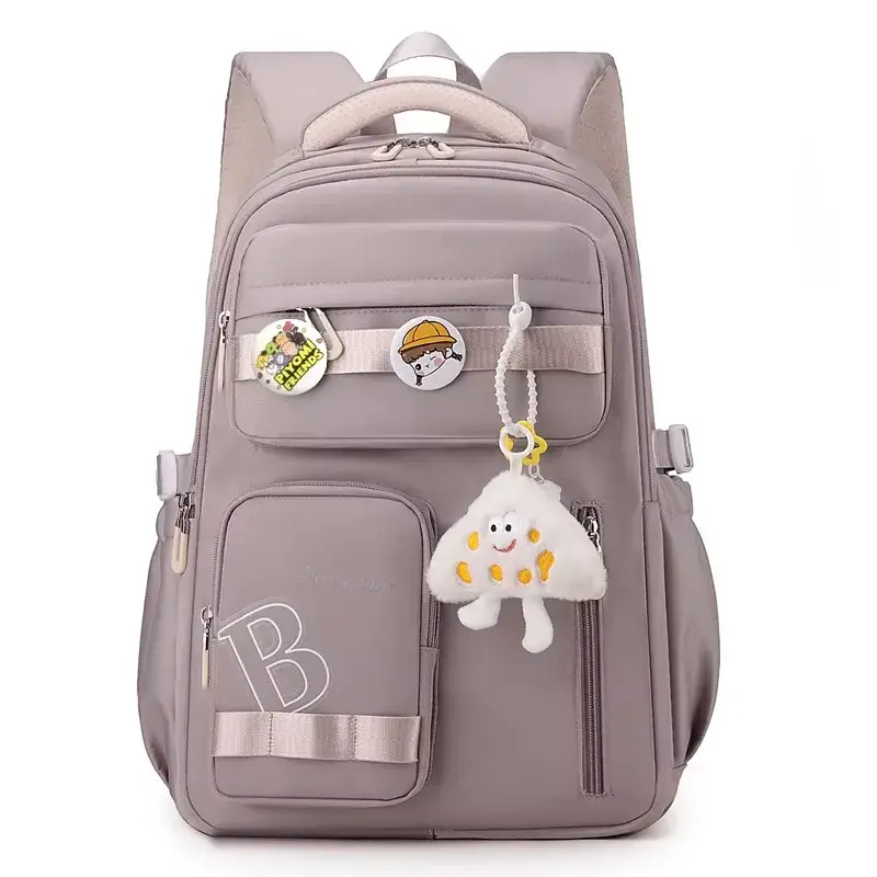 Vue de face du cartable scolaire fille violet clair grande capacité, orné de badges "PIYOMI FRIENDS" et d'un porte-clés peluche nuage, avec multiples poches zippées et lettrage "B" brodé.