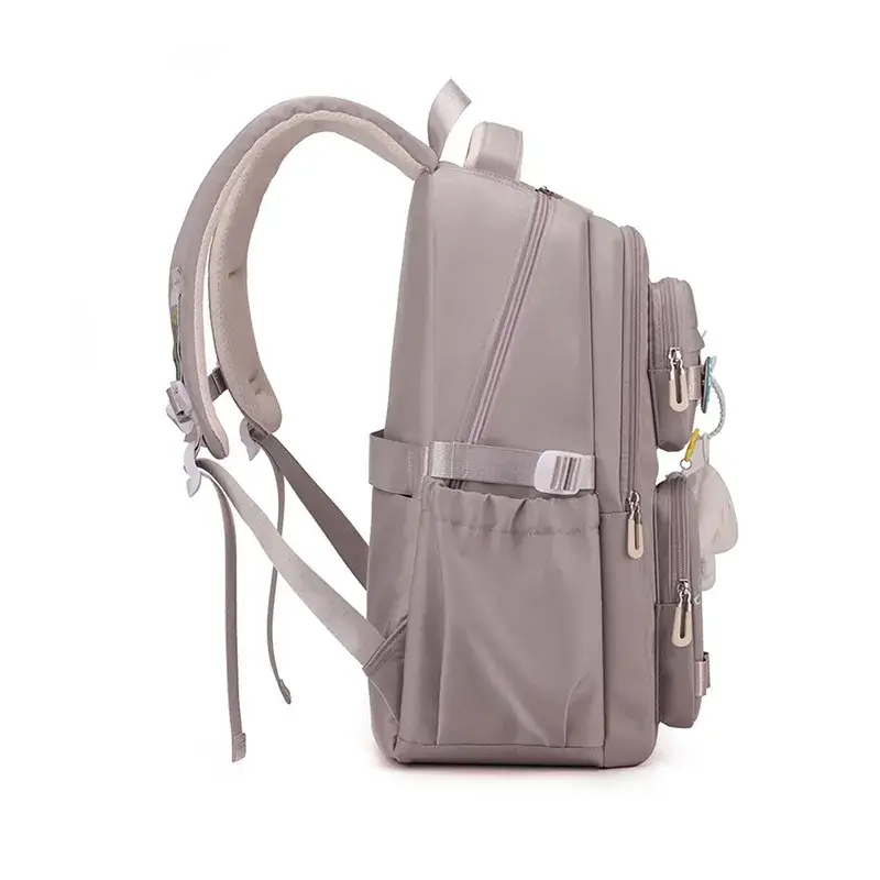 Vue latérale du sac à dos scolaire violet clair montrant les bretelles ergonomiques rembourrées, la sangle de poitrine réglable et la poche latérale élastique pour gourde — confort et praticité pour l'enfant.