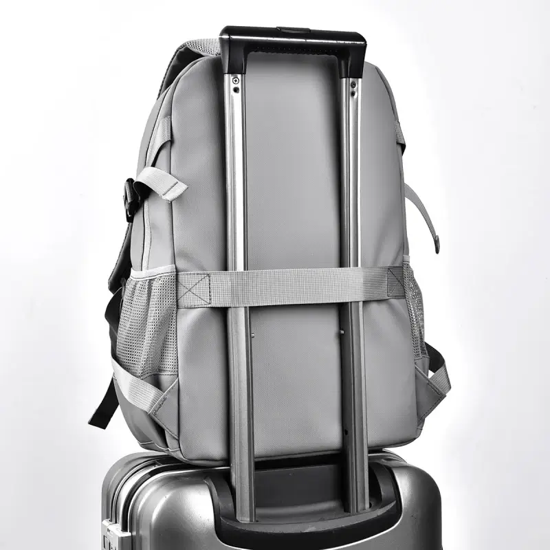 Dos du sac à dos étanche gris fixé sur une valise à roulettes grâce à la sangle bagage intégrée, fonction pratique pour les déplacements en avion, en train ou les voyages d'affaires.