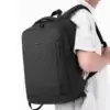 Homme portant le sac à dos business Wepower noir sur le dos, design sobre et élégant avec poche avant zippée verticale — idéal pour le travail, les déplacements et le transport d'ordinateur portable.