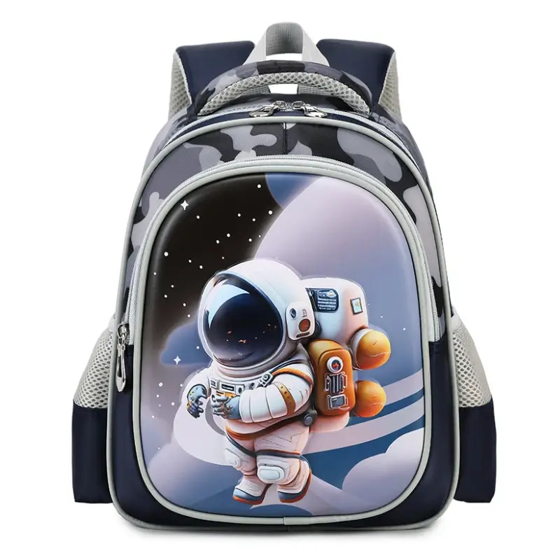 Sac à dos maternelle garçon avec motif camouflage gris et astronaute 3D en relief sur la poche avant, poches latérales en filet respirant et bretelles rembourrées — imperméable et léger, parfait pour l'école primaire et la crèche.
