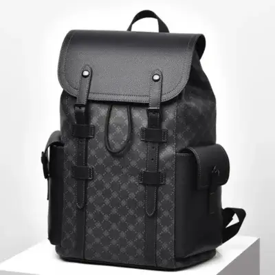 Sac à dos ordinateur homme 16 pouces noir avec motif monogramme élégant, rabat à boucles en cuir synthétique, poches latérales et cordon de serrage — design rétro imperméable et spacieux pour le travail, l'université et les déplacements professionnels.