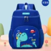Sac à dos enfant bleu roi avec dinosaure vert turquoise et hélicoptère rouge, poches latérales respirantes et tissu résistant à l'eau — cartable garçon robuste et coloré parfait pour la rentrée à la maternelle.