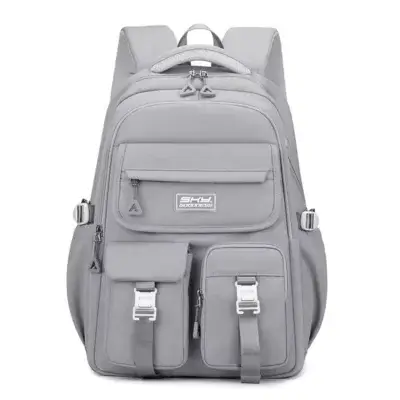 Vue de face du sac à dos fille gris pastel sur fond blanc, design minimaliste avec compartiments organisés, sangles de compression et tissu résistant à l'eau — cartable ergonomique moderne et spacieux pour le quotidien.
