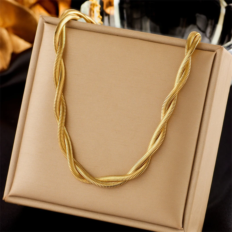Collier torsadé doré pour femme avec design tressé style chaîne serpent, drapé élégamment sur un coffret à bijoux fermé — accessoire de mode chic, intemporel et parfait pour accessoiriser une tenue. Copy Ask Qwen Explain Translate(en-US)