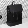 Sac à dos noir en tissu Oxford posé sur fond de grille métallique avec un casque audio à côté, mettant en valeur son design minimaliste et moderne — sac de voyage pratique et tendance pour jeune actif et étudiant.