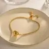 Bracelet tendance en acier inoxydable plaqué or avec chaîne à billes et perle centrale dorée, fermoir coulissant ajustable — bijou minimaliste et élégant pour femme, parfait pour un look quotidien chic.