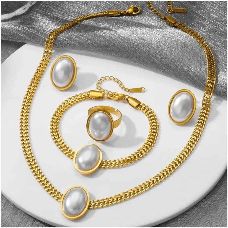 Ensemble complet de bijoux bohème vintage plaqué or comprenant collier, bracelet, bague et boucles d'oreilles, tous ornés d'un cristal ovale blanc nacré sur chaîne maille — parure femme coordonnée et sophistiquée, idéale pour un cadeau ou une occasion spéciale.